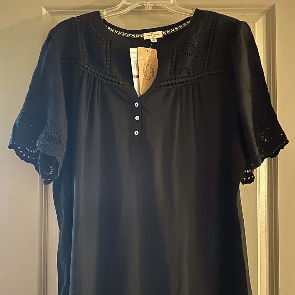 Beautiful black blouse. Eyelet style sleeps and lace detail and button neck.
